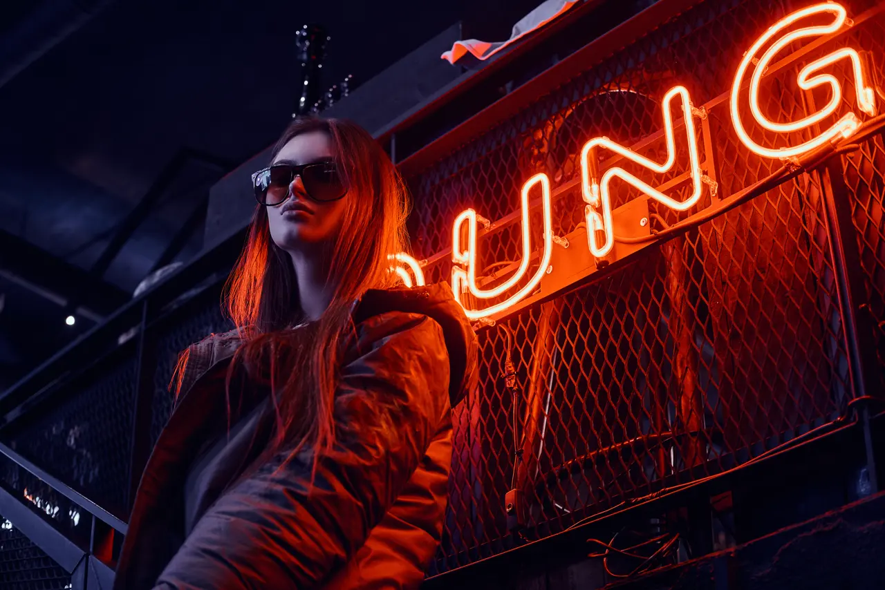 Music video shoot at night under a neon sign